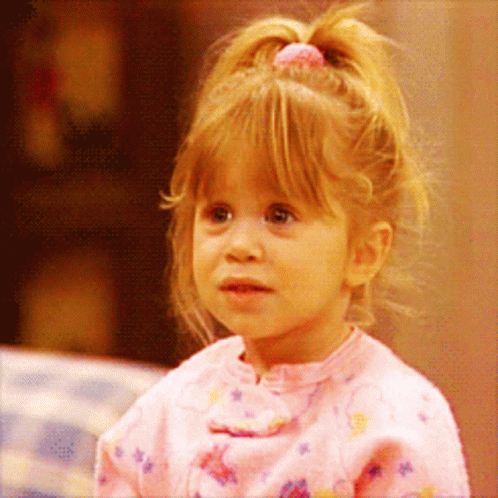 A Little Girl With A Pink Ponytail Is Wearing A Pink Shirt GIF