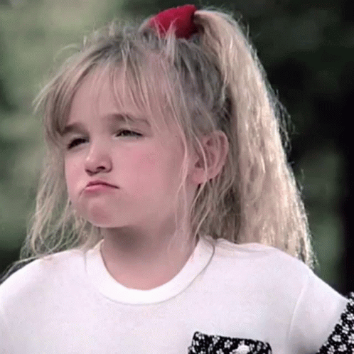 A Little Girl With A Red Bow In Her Hair Is Making A Face GIF