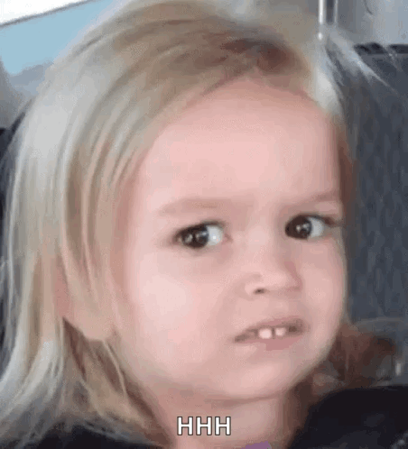 A Little Girl With Blonde Hair Is Making A Funny Face While Sitting In A Car Seat . GIF