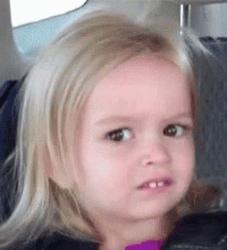 A Little Girl With Blonde Hair Is Sitting In A Car Seat . GIF