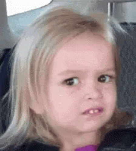 A Little Girl With Blonde Hair Is Sitting In A Car Seat Making A Funny Face . GIF