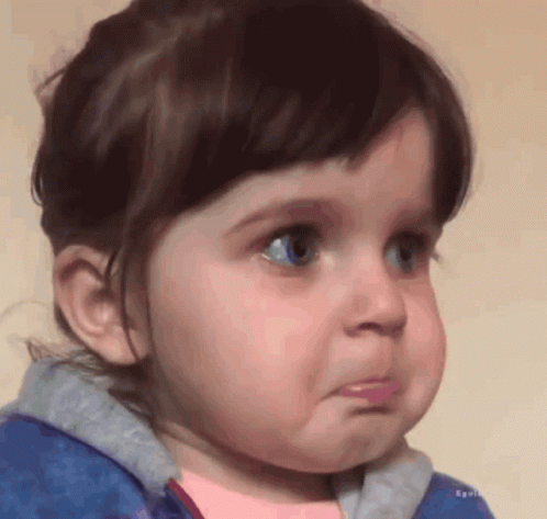 A Little Girl With Blue Eyes Is Making A Sad Face GIF