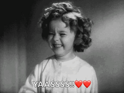A Little Girl With Curly Hair Is Smiling And Saying Yaasss ! GIF