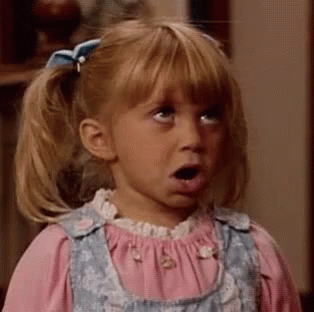 A Little Girl With Pigtails And A Bow On Her Hair Looks Surprised GIF