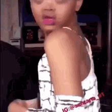 A Little Girl With Pink Lipstick On Her Lips Is Sitting In A Chair And Looking At The Camera . GIF
