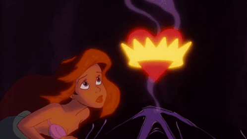 A Little Mermaid Looks At A Heart With A Crown Coming Out Of It GIF