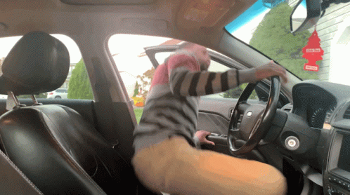 A Little Tree Air Freshener Hangs From The Rear View Mirror GIF