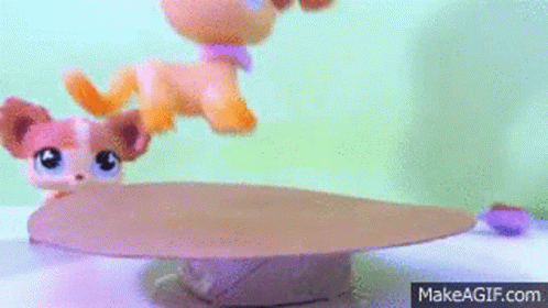 A Littlest Pet Shop Dog Is Standing On Top Of A Cardboard Box On A Table . GIF