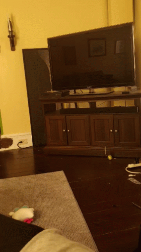 a living room with a flat screen tv on a wooden stand