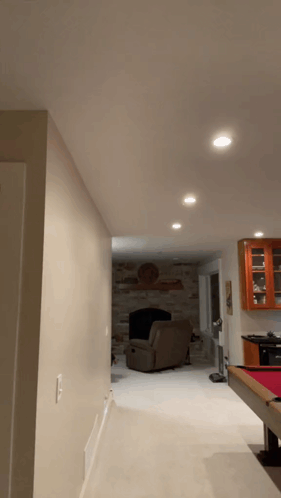 A Living Room With A Pool Table And A Chair GIF