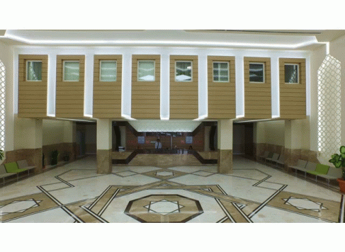 A Lobby With A Geometric Pattern On The Floor And A Counter GIF
