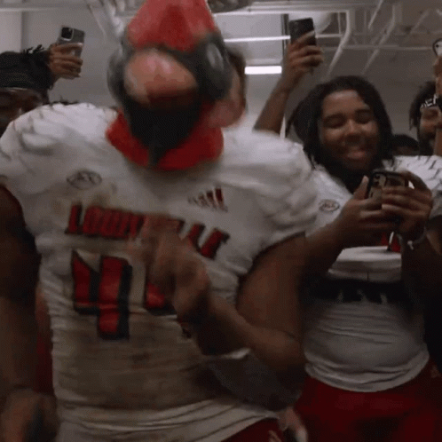 a louisville football player wearing a red cardinal mask