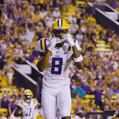 A Lsu Football Player Wearing A White Jersey With The Number 8 On It GIF