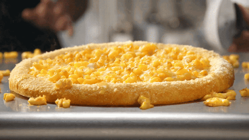 A Macaroni Cheese Pizza Is Sitting On A Pan GIF