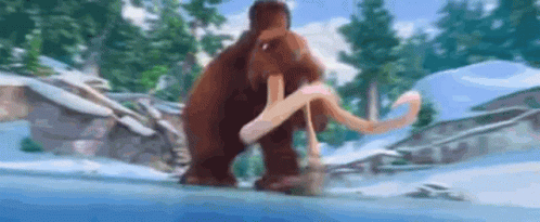 A Mammoth Is Walking Through The Snow In A Snowy Forest . GIF