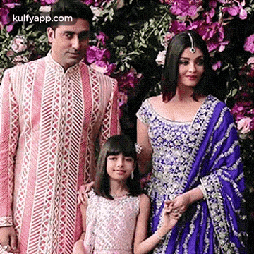 A Man , A Woman And A Little Girl Are Posing For A Picture Together . GIF