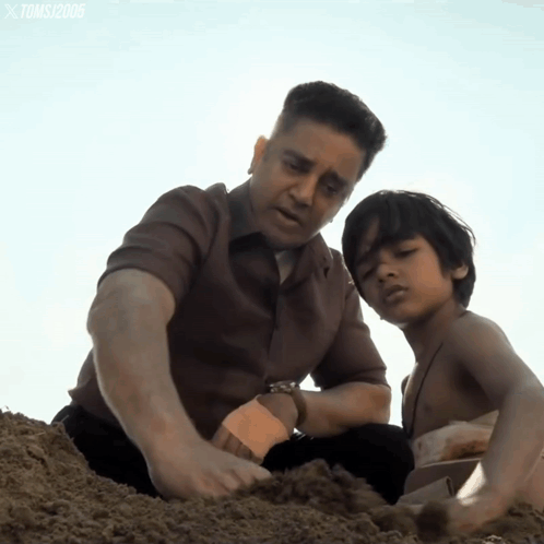 A Man And A Boy Are Playing In The Sand And The Watermark Toms 2006 Is On The Bottom Right GIF