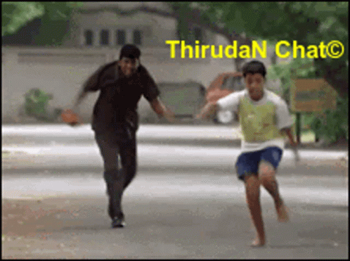 A Man And A Boy Are Running Down A Street With The Words Thirudan Chat On The Bottom Right GIF