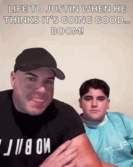 A Man And A Boy Are Sitting Next To Each Other And The Man Is Holding The Boy 'S Arm . GIF