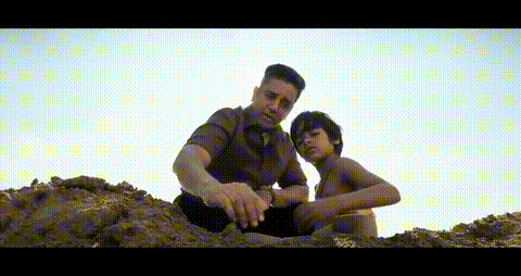 A Man And A Boy Are Sitting On Top Of A Hill Playing With Sand . GIF
