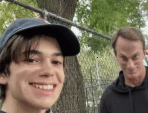 A Man And A Boy Are Standing Next To Each Other And Smiling GIF