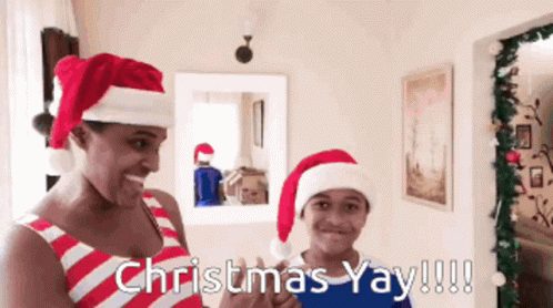 A Man And A Boy Wearing Santa Hats With The Words Christmas Yay !!! GIF