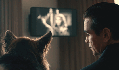 A Man And A Dog Are Looking At A Television GIF