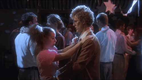 A Man And A Girl Are Dancing In A Crowded Room GIF