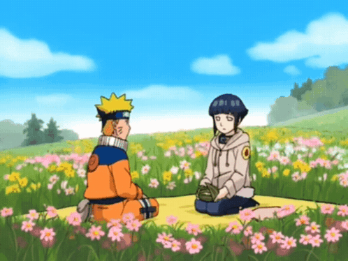 A Man And A Girl Are Sitting In A Field Of Flowers GIF