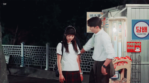 A Man And A Girl Standing In Front Of A Cigarette Vending Machine GIF