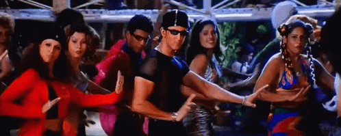 A Man And A Group Of Women Are Dancing Together In A Room . GIF