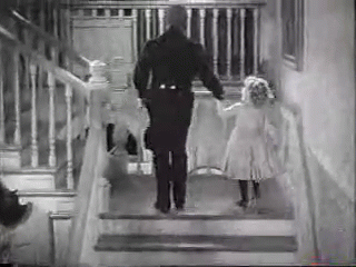 A Man And A Little Girl Are Walking Down Stairs Holding Hands . GIF