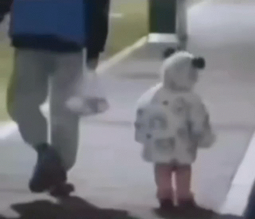 A Man And A Little Girl Are Walking Down The Sidewalk . GIF