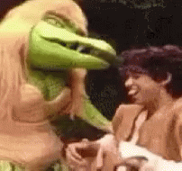 A Man And A Monster Are Standing Next To Each Other . GIF