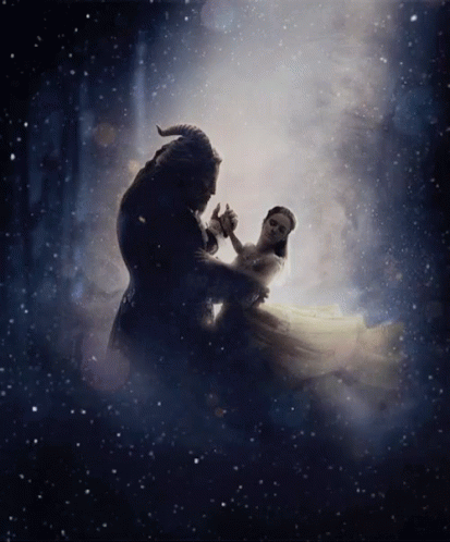 A Man And A Woman Are Dancing In A Dark Room . GIF