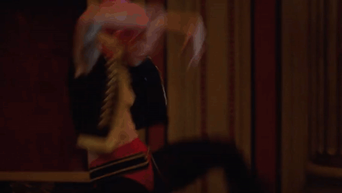 a man and a woman are dancing in a large hallway