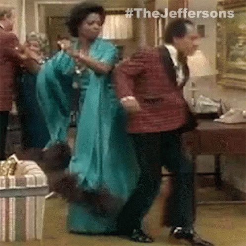 A Man And A Woman Are Dancing In A Room . GIF