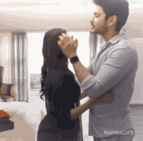 A Man And A Woman Are Dancing In A Room . GIF