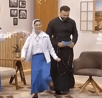 A Man And A Woman Are Dancing In A Room With A Nbc Logo On The Wall GIF