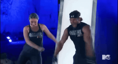 A Man And A Woman Are Dancing In Front Of A Mtv Sign GIF