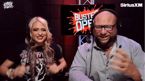 A Man And A Woman Are Dancing In Front Of A Screen That Says Bustf Opf GIF