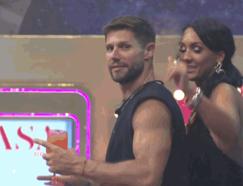 a man and a woman are dancing in front of a sign that says ' s ' on it