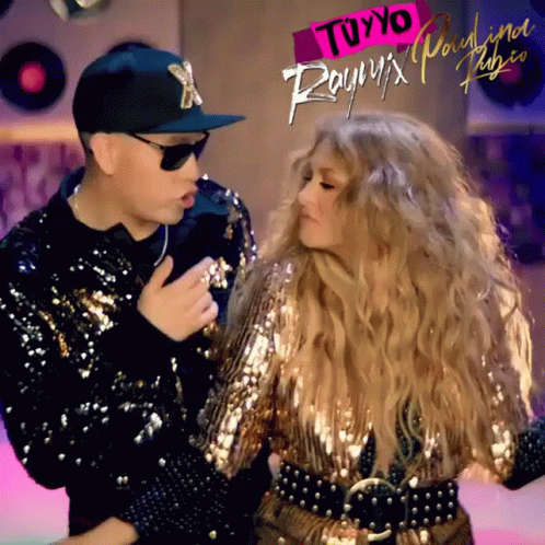 a man and a woman are dancing in front of a sign that says " tuyyo " on it