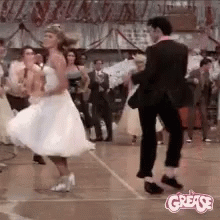 A Man And A Woman Are Dancing On A Dance Floor In A Room . GIF