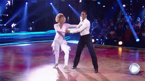A Man And A Woman Are Dancing On A Dance Floor In Front Of A Crowd That Is Watching A Show On Globo Tv GIF