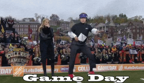 A Man And A Woman Are Dancing On A Field With The Words Game Day On The Bottom GIF