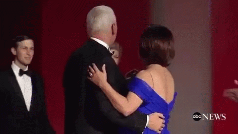 A Man And A Woman Are Dancing On A Red Carpet . GIF