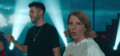 A Man And A Woman Are Dancing On A Stage With The Letters Rtve Behind Them GIF