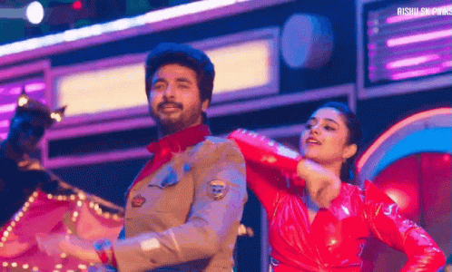 A Man And A Woman Are Dancing On Stage . GIF