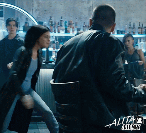 A Man And A Woman Are Fighting In A Bar With A Sign That Says Alita At The Bottom GIF